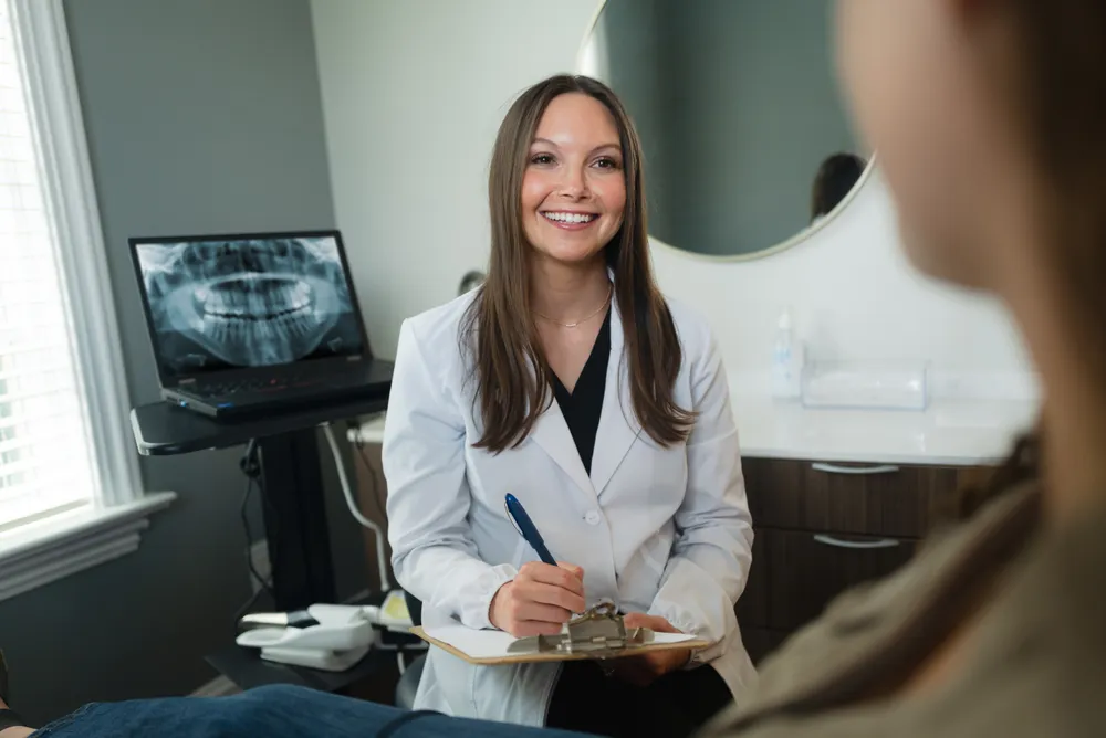 Dr. Brittany Henry consulting with a patient at Pearly White Dentistry.