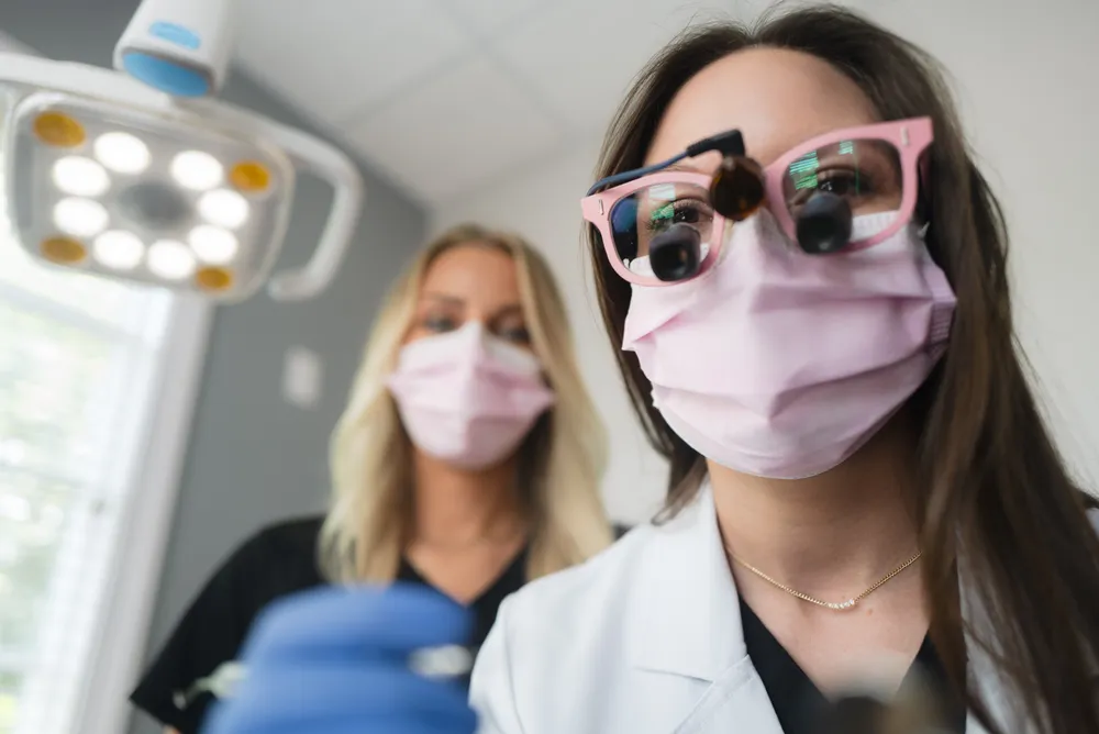 Dr. Henry and her assistant at work during a patient examination at Pearly White Dentistry.